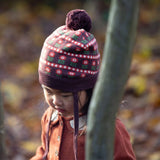 Child wearing a patterned knit hat in an autumn setting