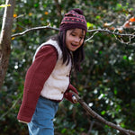 Child holding a stick in a forest setting