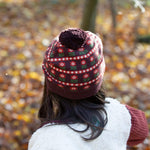 Child wearing a patterned knit hat in an autumn setting